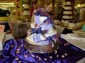 3 TIER ROLLED FONDANT WITH DRAPE AND PURPLE FLOWERS